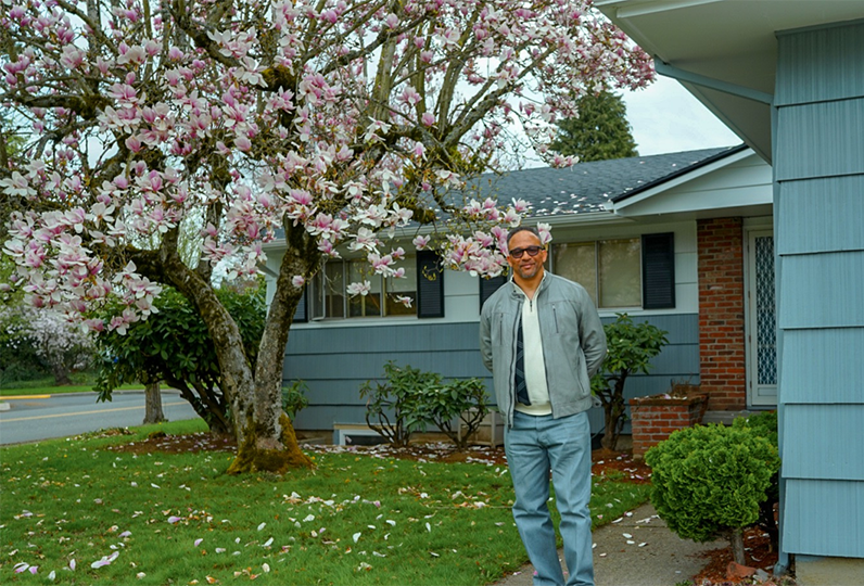 Man standing in front of the Harry Watson house
