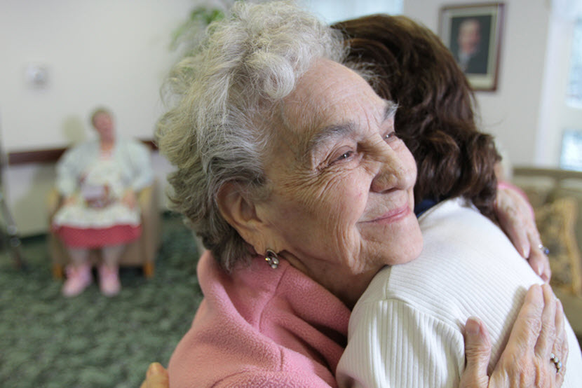 Volunteers of America employee hugging a senior housing client